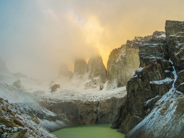 Chile - Patagonia: Early in the morning the Torres were still covered in clouds. The higher the sun rose the more clouds dissipated and the rocks finally were revealed